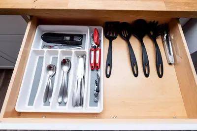 a drawer with utensils in a wooden cabinet at The Palms at Middle River Terrace 4 in Fort Lauderdale