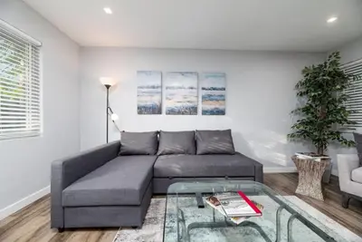 a living room with a gray couch and a glass table at The Palms at Middle River Terrace 4 in Fort Lauderdale