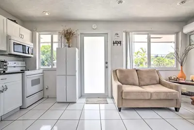 a living room with a couch and a refrigerator at Fort Lauderdale Duplex about 5 Mi to Downtown! in Fort Lauderdale