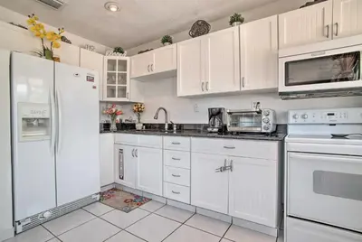 a white kitchen with white appliances and white cabinets at Fort Lauderdale Duplex about 5 Mi to Downtown! in Fort Lauderdale