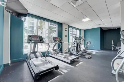 a gym with several tread machines in a room at Great apartment in Hollywood with side ocean view! Direct access to the beach! 14th floor in Hollywood