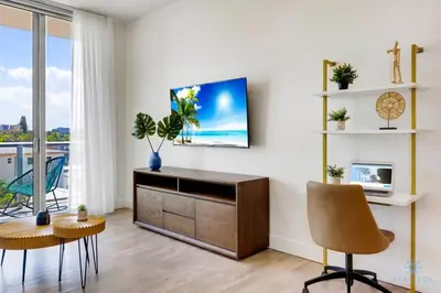 a living room with a tv on a white wall at Amazing Pool - Balcony - Up To 6 - Near Beach in Hollywood
