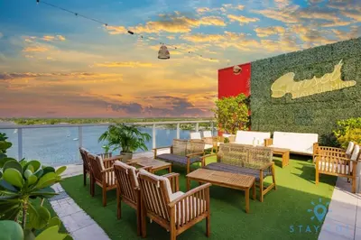a patio with tables and chairs on a balcony at Amazing Pool - Gym - Hot Tub - Near Beach in Hollywood