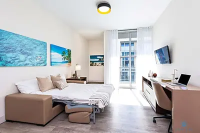 a bedroom with a bed and a desk with a computer at Rooftop Pool, Broad-walk & Near Beach in Hollywood