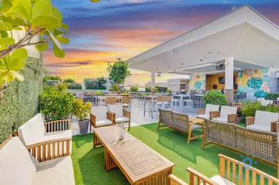 an outdoor patio with tables and chairs and a sunset at Rooftop Pool - Balcony - Hollywood Beach - Gym in Hollywood
