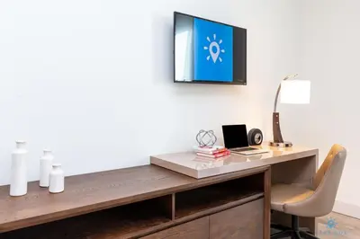 a desk with a chair and a tv on a wall at Hot tub & Rooftop pool - Near Beach in Hollywood