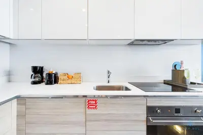 a kitchen with white cabinets and a sink at Ocean View Balcony - Rooftop Pool & Hot Tub - Gym in Hollywood