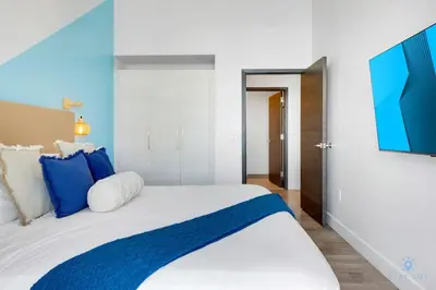 a bedroom with a bed with blue and white pillows at Ocean View Balcony - Rooftop Pool & Hot Tub - Gym in Hollywood