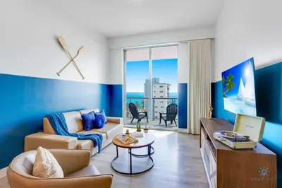a living room with a couch and a table at Ocean View Balcony - Rooftop Pool & Hot Tub - Gym in Hollywood