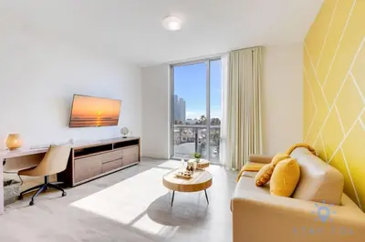 a living room with a couch and a desk at Lovely Apartment - Hollywood Beach - Rooftop Pool in Hollywood