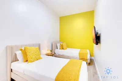 two beds in a small room with yellow walls at Lovely Apartment - Hollywood Beach - Rooftop Pool in Hollywood