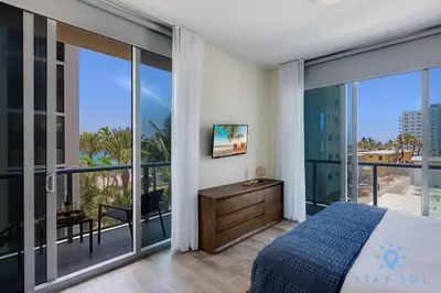 a bedroom with a bed and a large window at Ocean View - Balcony - Rooftop Pool - Hollywood Beach in Hollywood