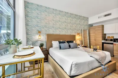 a bedroom with a large bed and a kitchen at Best Stay - Rooftop Pool & Hot Tub - Hollywood Beach in Hollywood