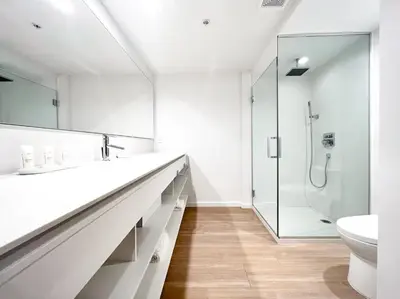 a white bathroom with a sink and a shower at Beach Haus Residences in Bal Harbour