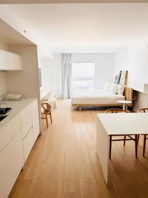 a kitchen and living room with a bed and a table at Beach Haus Residences in Bal Harbour