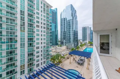 an apartment balcony with blue chairs and a pool at 4BR APT with Bay View at Brickell, Free Parking in Miami