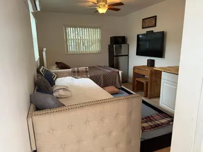 a living room with a couch and a flat screen tv at El Shaddai Faithfully Beach in Hollywood