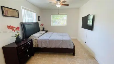 a bedroom with a bed and a ceiling fan at El Shaddai Faithfully Beach in Hollywood