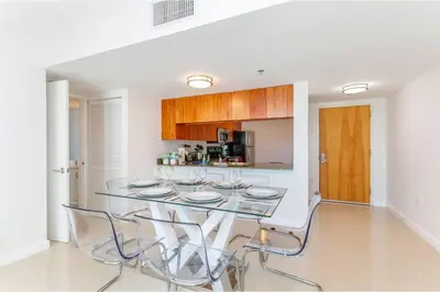 a dining room with a glass table and chairs at Stunning 2BR with Ocean View at Brickell, Free Parking in Miami