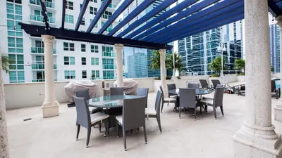 a patio with tables and chairs on a building at Stunning 2BR with Ocean View at Brickell, Free Parking in Miami