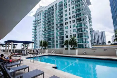 a large building with a swimming pool in front of a building at Bright and Cozy 2BR at Brickell, Free Parking in Miami