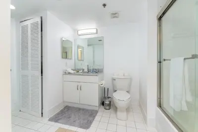 a bathroom with a toilet and a sink and a shower at Bright and Cozy 2BR at Brickell, Free Parking in Miami