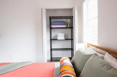 a bedroom with a bed and a shelf with towels at Casa MIA central location, free parking, fully equipped in Miami
