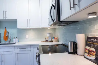 a kitchen with white cabinets and a counter top at Casa MIA central location, free parking, fully equipped in Miami