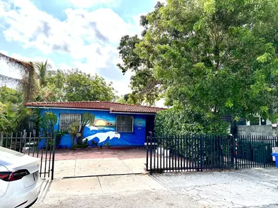 a blue house with a fence in front of it at Miami House in Miami