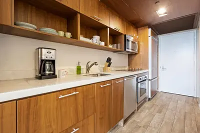a kitchen with wooden cabinets and a sink at Biscayne Bay View Stay Pool Hot Tub and Amenities in Miami