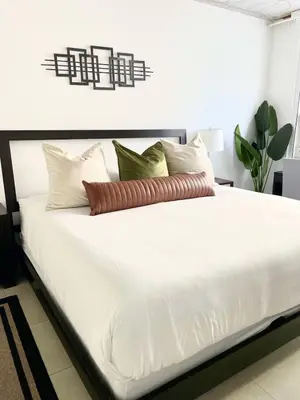 a bed with white sheets and pillows in a room at City Condo in Midtown Wynwood with pool and parking in Miami