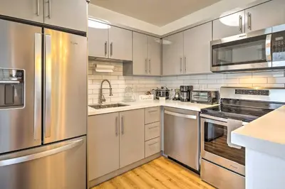 a kitchen with white cabinets and stainless steel appliances at Central Miami Home about 10 Mi to Local Beaches! in Miami
