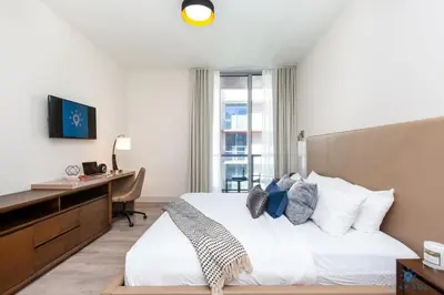 a bedroom with a bed and a desk with a computer at Hollywood Beach Broad-walk - Pool - Gym & Hot Tub in Hollywood