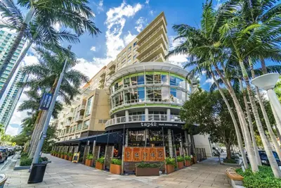 a building with palm trees in front of it at Classy 2BD 2BTH at Midblock with FREE PARKING in Miami