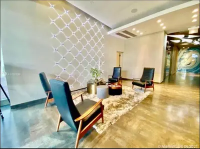 a lobby of a hotel with chairs and a table at Classy 2BD 2BTH at Midblock with FREE PARKING in Miami
