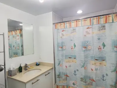 a bathroom with a shower curtain and a sink at Classy 2BD 2BTH at Midblock with FREE PARKING in Miami