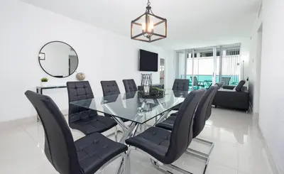 a dining room with a glass table and black chairs at YP PROPERTY MANAGEMENT in Hollywood