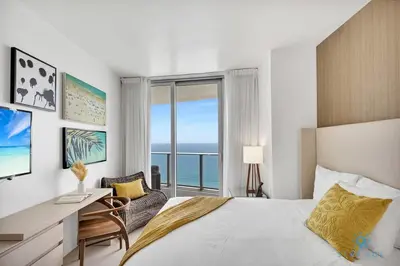 a bedroom with a bed and a desk and a window at Insane Ocean View Balcony- Beachfront Resort - Pools in Hollywood
