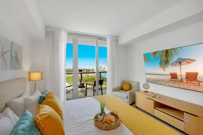 a bedroom with a bed with a view of the beach at Infinite Views with Amazing Pool plus Gym, Near Beach in Hallandale Beach
