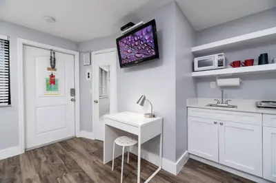 a kitchen with a white desk and a tv on the wall at Shell on the Beach 104 - RENOVATED in Hollywood