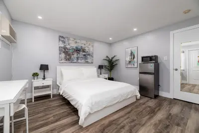 a white bedroom with a bed and a desk at Shell on the Beach 105 - RENOVATED in Hollywood