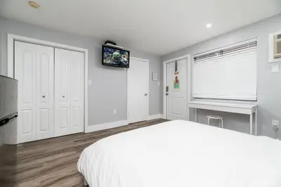 a white bedroom with a bed and a desk at Shell on the Beach 105 - RENOVATED in Hollywood