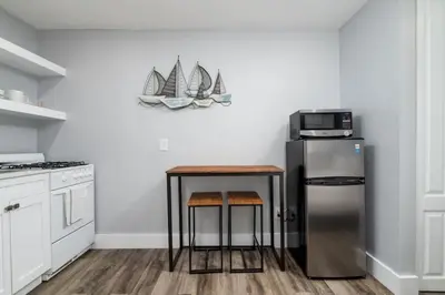 a kitchen with two stools and a refrigerator at Shell on the Beach 106 - RENOVATED in Hollywood