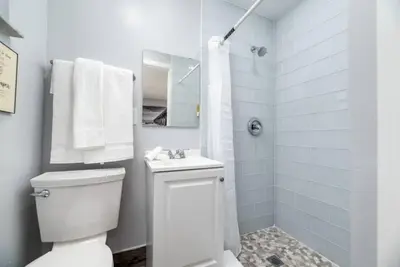 a white bathroom with a toilet and a shower at Shell on the Beach 106 - RENOVATED in Hollywood