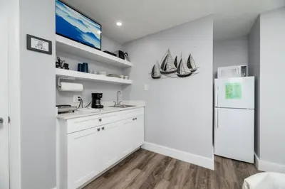 a kitchen with white cabinets and a white refrigerator at Shell on the Beach 102 - RENOVATED in Hollywood
