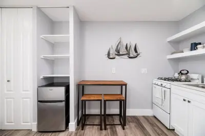 a kitchen with a table and a stool in it at Shell on the Beach 103 - RENOVATED in Hollywood