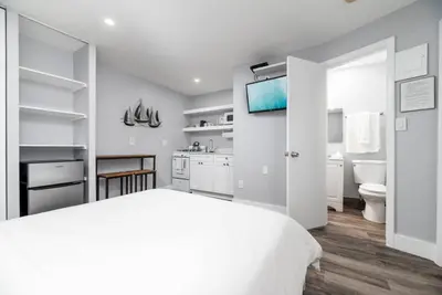 a white bedroom with a white bed and a bathroom at Shell on the Beach 103 - RENOVATED in Hollywood
