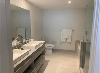 a bathroom with two sinks and a toilet and a mirror at Luxury apartment- Hyde House Resort in Hollywood