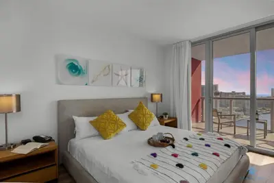a bedroom with a large bed and a large window at Infinite View with Balcony,Pool plus Near Beach in Hallandale Beach