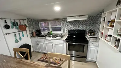 a kitchen with a stove and a sink and a table at Private Rooms in Miami